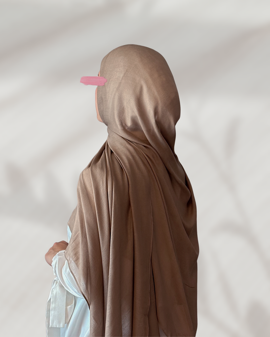 Person wearing a brown hijab against a plain background